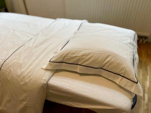 a bed with white sheets and pillows on it at Down-Town 1 Bedroom Flat in Brussels
