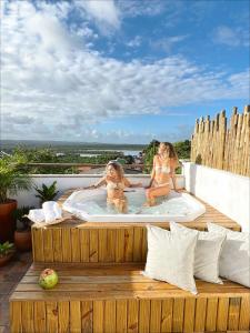 two girls in bathing suits sitting in a hot tub at Nomads Flats in Itacaré
