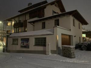 ein Haus im Schnee vor einem Gebäude in der Unterkunft Appartement Posthäusl in Sölden