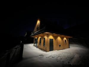 een houten hut in de sneeuw 's nachts bij Górska Ostoya in Szlembark