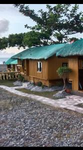 a building with a green roof on the beach at Sea Breeze Beachfront Home and Cottages in San Juan