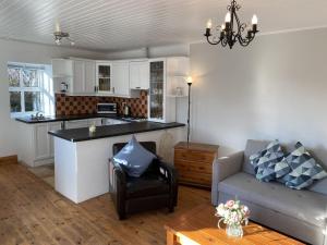 ein Wohnzimmer mit einem Sofa und einer Küche in der Unterkunft Cottage 433 - Ballyconneely in Ballyconneely