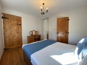 a bedroom with a bed and two wooden doors at Cottage 433 - Ballyconneely in Ballyconneely