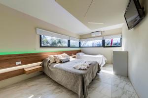 a bedroom with a bed and a flat screen tv at Soho Village in Villa Carlos Paz