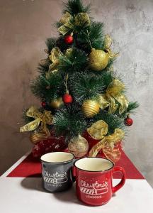 a christmas tree with two coffee cups in front of a christmas tree at Studio IKA Belgrade Airport Free Parking possible Self Check-In Terrace in Ledine +9 photos