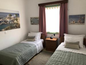 a bedroom with two beds and a window at Celia in Adamas