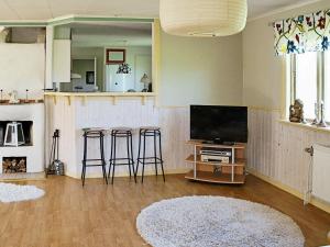 een woonkamer met een televisie en 2 barkrukken bij Holiday Home Svedhagen in Edsbruk