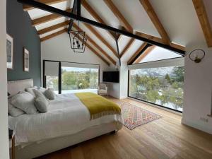 a bedroom with a large bed and large windows at Imponente casa en Arelauquen Golf & Country Club in San Carlos de Bariloche +73 photos