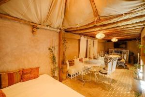 Zimmer mit einem Bett, einem Tisch und Stühlen in der Unterkunft Riad Minami in Marrakesch