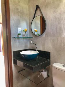 a bathroom with a bowl sink and a mirror at Vila Verde Chalés-Serro in Sêrro