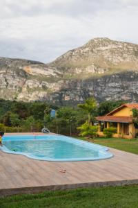 a swimming pool with a mountain in the background at Pousada Bela Vista do Ismail - Lapinha da Serra in Santana do Riacho