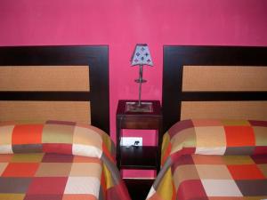 a bedroom with two beds and pink walls at Apartamento Rural en Sotosalbos in Sotosalbos