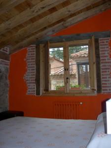 Habitación con pared de color naranja y ventana en Apartamento Rural en Sotosalbos, en Sotosalbos