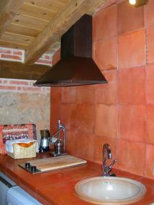 a kitchen counter with a sink and a black hood at Apartamento Rural en Sotosalbos in Sotosalbos