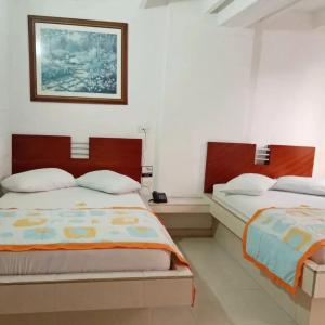 um quarto com duas camas e uma foto na parede em Hotel Ibiza em Armênia