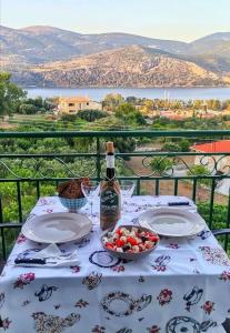 un tavolo con una bottiglia di vino e un cesto di frutta di Apaggio di Argostoli Apartment! private parking & sea view! ad Argostoli