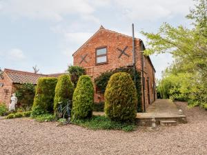 a brick house with bushes in front of it at Clare's Cottage in Grainthorpe