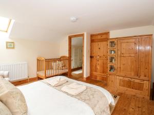 a bedroom with a large bed and a crib at Clare's Cottage in Grainthorpe