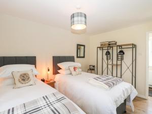 1 dormitorio con 2 camas con sábanas blancas en Orchard House Cottage, en Malmesbury