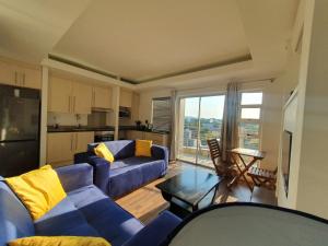 uma sala de estar com um sofá azul e uma cozinha em Unit 26, Genesis em Joanesburgo