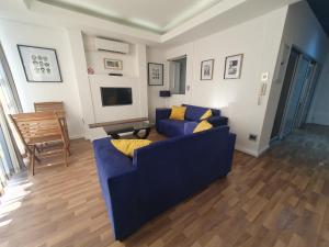 sala de estar con sofá azul y TV en Unit 26, Genesis en Johannesburgo