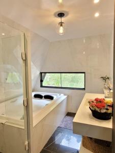 een badkamer met een bad, een wastafel en een tafel bij Cabana A frame Paraíso nas Montanhas in Marechal Floriano
