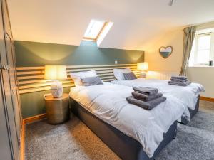 um quarto com 2 camas e toalhas em Tyn Y Ceubren Bach at Evelyns Retreat em Corwen