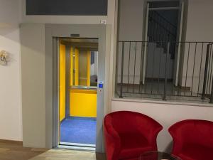 a room with two red chairs and a yellow door at Casa vacanza Locanda diffusa Madonna delle Grazie in Itri +42 photos