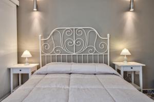 a bedroom with a large bed with two tables at Borgo suites - self catering apartments - Valletta - By Tritoni Hotels in Valletta