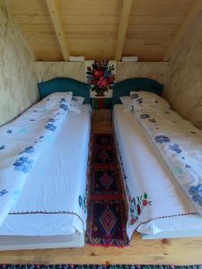two twin beds in a room with wooden ceilings at Konak Mara- Komovi in Andrijevica