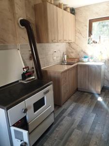 Andrijevica的住宿－Konak Mara- Komovi，厨房配有木制橱柜和炉灶烤箱。