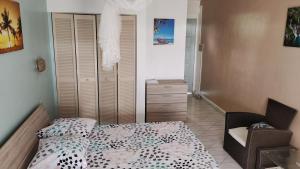 une petite chambre avec un lit et une chaise dans l'établissement Résidence Frangipaniers, à Sainte-Anne