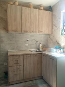 a kitchen with wooden cabinets and a sink at Konak Mara- Komovi in Andrijevica