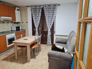 sala de estar con mesa, sofá y cocina en LA TERRAZA en Teruel