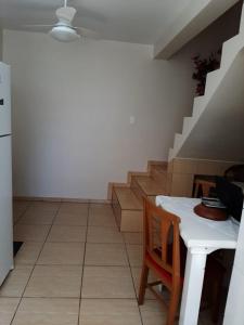 sala de estar con mesa y escalera en Apartamento Atobá, en Florianópolis