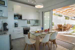 a kitchen with a table and chairs and a dining room at Villa Cassandra - A breathtaking view of Souda-Chania bay and the White Mountains in Kókkinon Khoríon