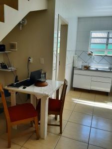 una cocina con mesa y ordenador portátil. en Apartamento Atobá, en Florianópolis