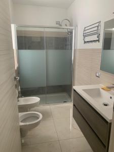 La salle de bains est pourvue d'une douche, de toilettes et d'un lavabo. dans l'établissement Affittacamere EROI, à Feriolo