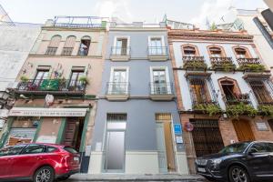 a building on a street with cars parked in front at Loft duplex Sevilla wall in Seville