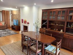 a dining room with a wooden table and chairs at GEMA Village in Coimbra