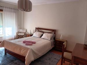 a bedroom with a bed with two towels on it at GEMA Village in Coimbra