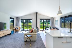 a kitchen and living room with a couch and a table at Mata-Au River Sanctuary in Wanaka