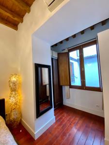 uma sala de estar com uma grande janela e pisos em madeira em Duplex Toledo Catedral con parking gratis em Toledo