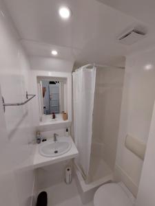 a white bathroom with a sink and a shower at Summer House emeleti szoba in Debrecen