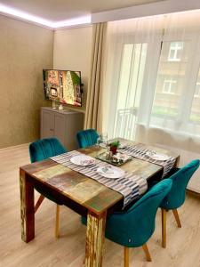 een eettafel met blauwe stoelen en een tafel en een raam bij Brand New, Design Apartment JoJo, OldTown, Balcony in Bratislava