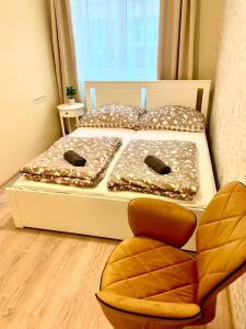 een slaapkamer met 2 bedden en een stoel aan de voorzijde bij Brand New, Design Apartment JoJo, OldTown, Balcony in Bratislava