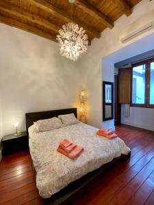 a bedroom with a large bed and a chandelier at Duplex Toledo Catedral con parking gratis in Toledo