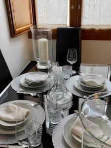 a table with plates and glasses and a candle on it at Duplex Toledo Catedral con parking gratis in Toledo