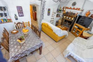 sala de estar con mesa y sofá amarillo en Casa cueva con encanto en Terque