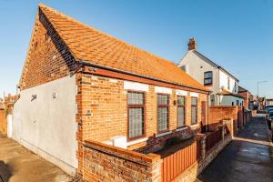 a brick building with an orange roof on a street at The Old Bakery - Norfolk Holiday Properties in Great Yarmouth